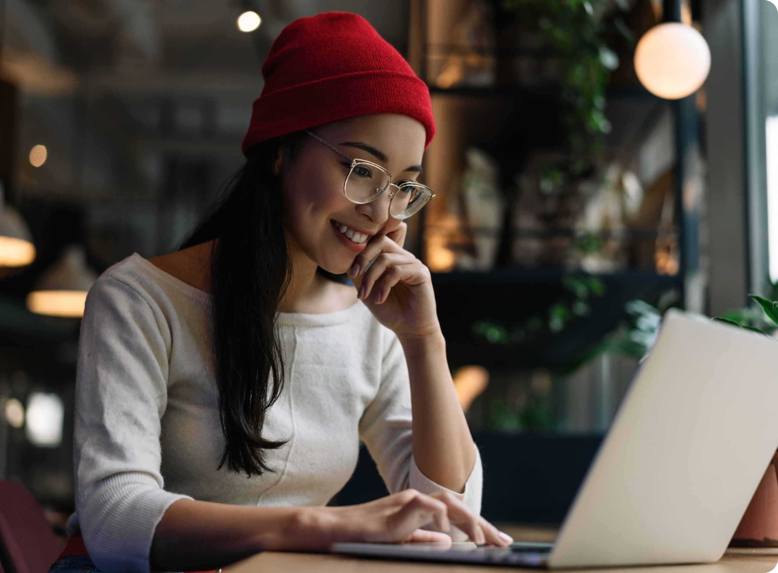 A smiling student studying on a laptop